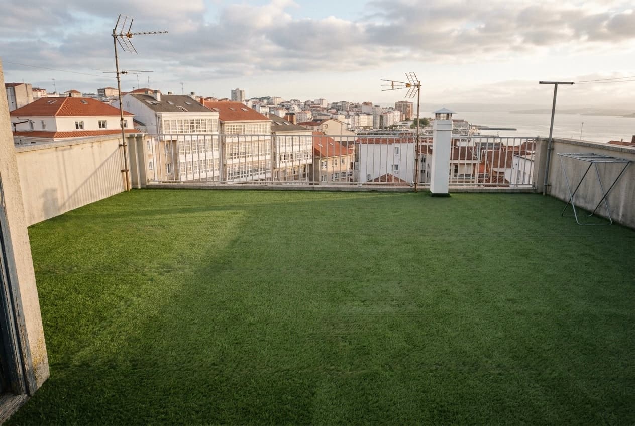 Los 90 m² de césped artificial de 22 mm terminados en la azotea, desmontables por paños, con la ría al fondo