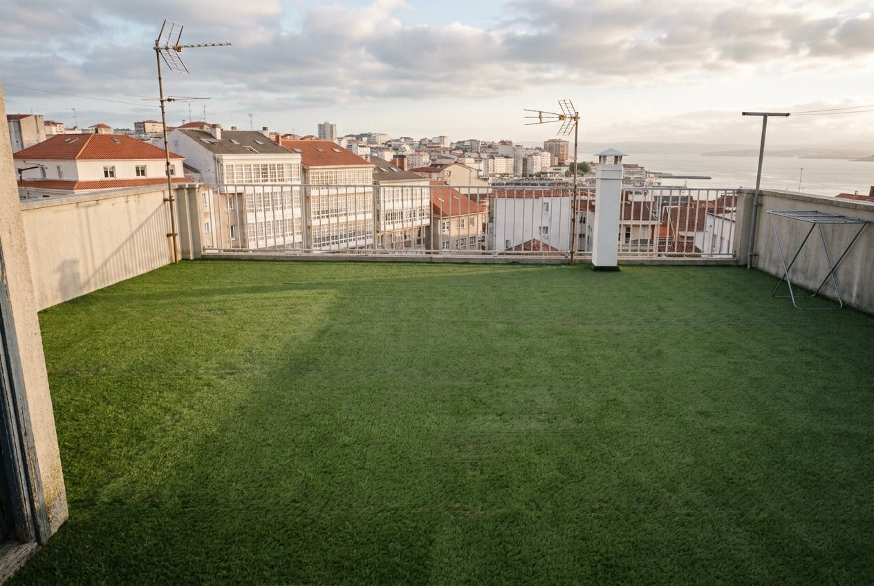 Los 90 m² de césped artificial de 22 mm terminados en la azotea, desmontables por paños, con la ría al fondo